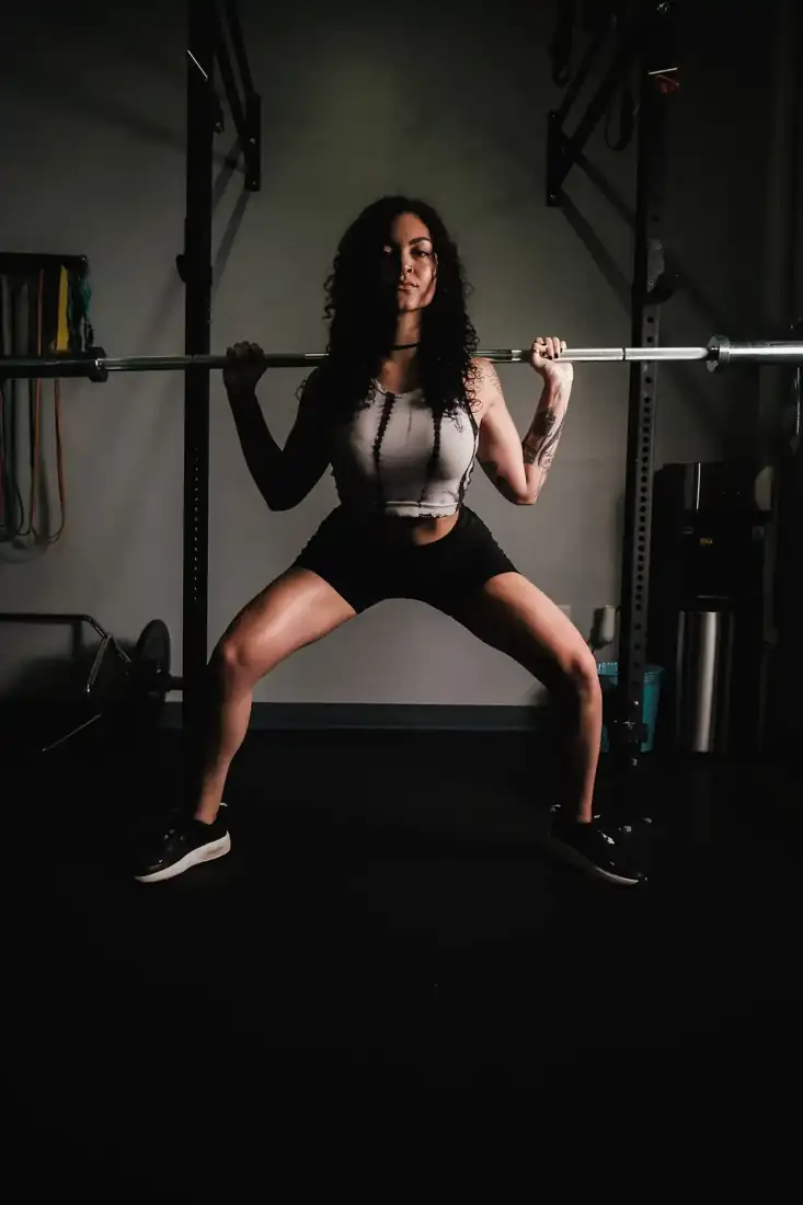 Kai, a coach, holding a barbell squat
