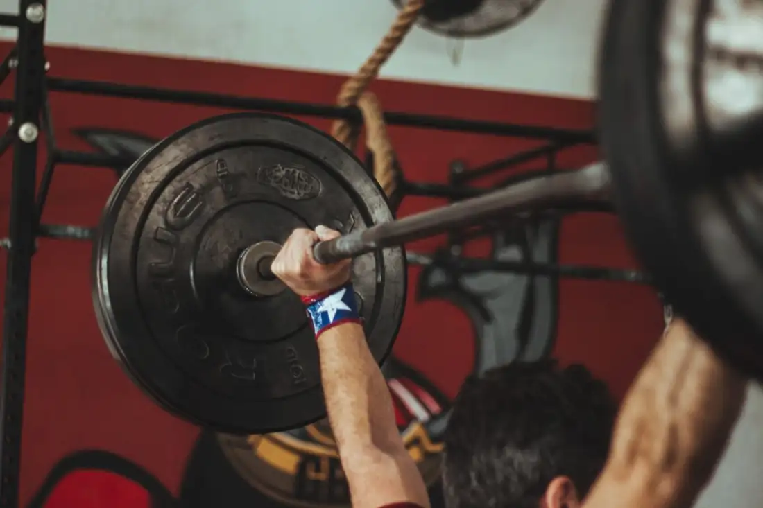 Hands gripping a loaded barbell