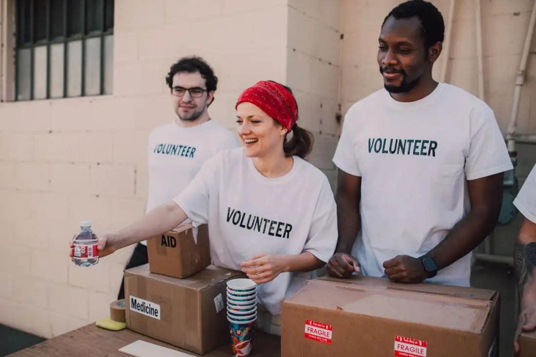 Volunteers in matching shirts packing donation boxes